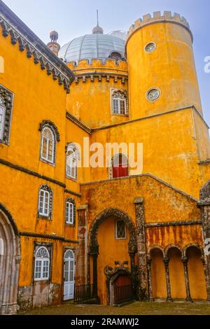 Die farbenfrohe zylindrische Bastion im Neuen Palast im Innenhof der Bögen des Palastes Pena oder die historische Burg Palácio da Pena in Sintra, Portugal. Das Märchenschloss gilt als eines der schönsten Beispiele der portugiesischen Romantik aus dem 19. Jahrhundert der Welt. Stockfoto