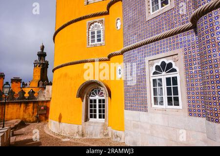 Geometrische maurisch gemusterte Fliesen schmücken die Fassade auf der Vorderterrasse des Pena-Palastes oder des historischen Schlosses Palácio da Pena in Sintra, Portugal. Das Märchenschloss gilt als eines der schönsten Beispiele der portugiesischen Romantik aus dem 19. Jahrhundert der Welt. Stockfoto