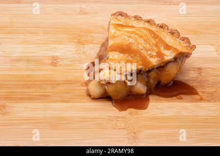 Ein tieferes Apfelkuchen mit Karamell, isoliert auf einem Holzbrett. Stockfoto