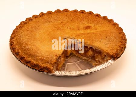 Ein doppelkrustender Apfelkuchen mit einem fehlenden Stück, in einer Dose und isoliert. Stockfoto