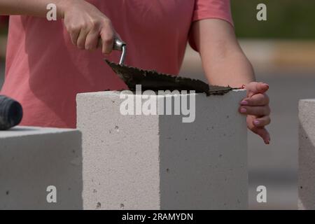 Der Maurer funktioniert. Bau einer Wand aus Porenbeton. Stockfoto