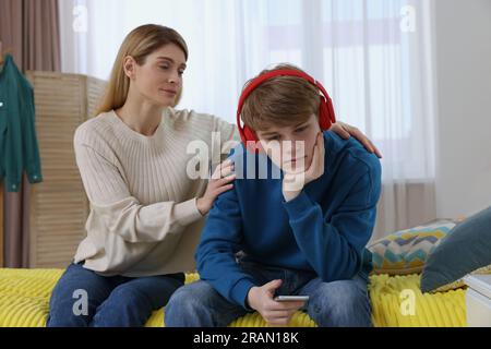 Mutter tröstet ihren verärgerten Teenager-Sohn zu Hause Stockfoto