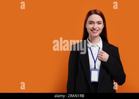 Glückliche Frau mit vip-Pass-Abzeichen auf orangefarbenem Hintergrund. Platz für Text Stockfoto