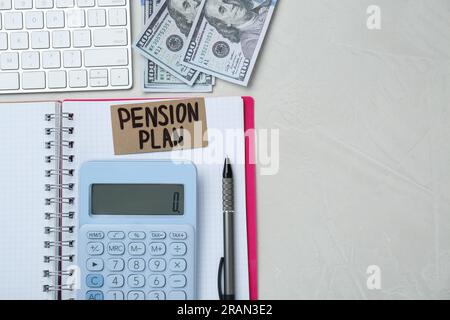 Karte mit Worten Pensionsplan, Banknoten, Taschenrechner und Notizbuch auf weißem Bürotisch, flach liegend. Platz für Text Stockfoto