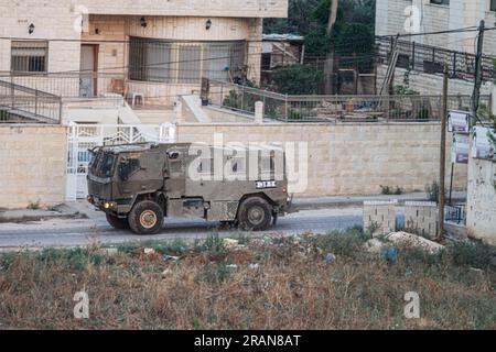 Dschenin, Palästina. 04. Juli 2023. Ein israelisches Militärfahrzeug verlässt das Flüchtlingslager Dschenin, während gleichzeitig Dutzende anderer Fahrzeuge das Lager stürmen. Palästinensische Gesundheitsbehörden sagten, dass mindestens 10 Palästinenser bei israelischen Angriffen und Luftangriffen ums Leben kamen. Daniel Hagari, Sprecher der Armee, sagte, Israel habe die Operation eingeleitet, weil im vergangenen Jahr etwa 50 Angriffe von Dschenin ausgingen. Kredit: SOPA Images Limited/Alamy Live News Stockfoto