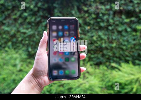 Kuala Lumpur, Malaysia - 29. Juni 2023: Nahaufnahme einer Hand mit einem Mobiltelefon und Facebook-App-Symbol, einer leistungsstarken Anwendung für soziale Medien. Stockfoto