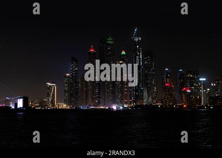 Die Skyline von Dubai Marina nach Sonnenuntergang mit einem Meer im Vordergrund. Wunderschöne Nachtsicht auf die Wolkenkratzer von Dubai vom Meer aus. Stockfoto