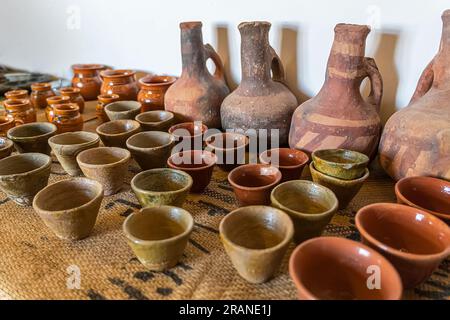 Kleine Kaffeetassen und eine Kanne auf dem Tisch. Keramik, ein Keramikprodukt, das mit eigenen Händen hergestellt wurde, hergestellt auf einem Töpferrad, Krug, Becher, Ton, Ziergegenstände. Stockfoto