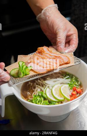 Gegrillte Nudelsuppe mit Schweinehals, isoliert auf weißem Hintergrund. Stockfoto
