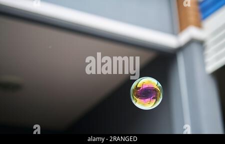 Eine schwebende Blase mit Reflexionen eines Hauses, ein konzeptionelles Bild, eine Immobilienblase. Stockfoto