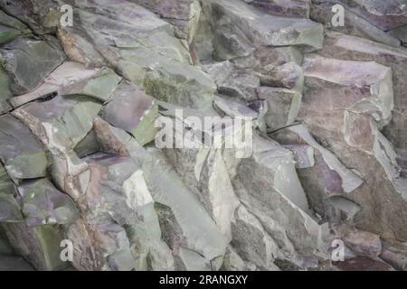 Ein Teil einer Steinmauer oder einer Felswand aus der Nähe. Natürlicher abstrakter Hintergrund aus Stein. Stockfoto