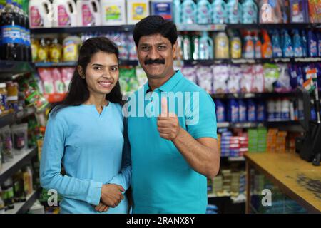 Vater Tochter kauft im Supermarkt ein. Ich kaufe Lebensmittel für zu Hause im Supermarkt. Fröhlicher Vater und fröhliche Tochter, die im Einkaufszentrum Daumen hoch halten. Stockfoto