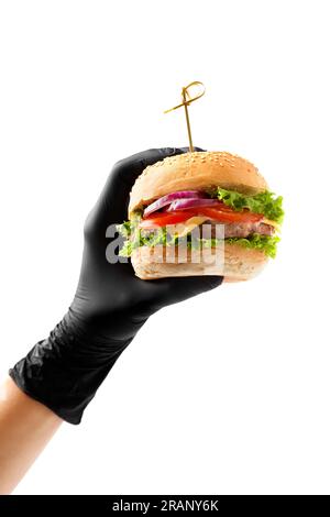 Eine Hand in einem schwarzen Handschuh hält einen saftigen, appetitlichen Rindfleischburger auf weißem Hintergrund. Hamburger in Händen isoliert. Banner, Fast-Food-Werbung. Stockfoto