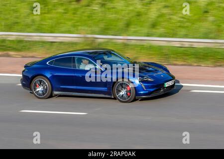 2022 Blue Porsche Taycan 4S 79Kw, 530PS Overboost 79,2Kwh Elektrische Auto-Limousine Strom 320 kW Geschwindigkeit auf der Autobahn M6 im Großraum Manchester, Großbritannien Stockfoto