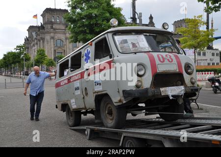 Berlin, Deutschland. 05. Juli 2023. Am 5. Juli 2023 wurde vor dem parlament in Berlin, Deutschland, ein von Ukrainern in Derhachi in der Nähe von Charkiv, Ukraine, eingesetzter Krankenwagen installiert, um auf russische Kriegsverbrechen aufmerksam zu machen. Ukrainische, litauische und deutsche Aktivisten standen hinter der Aktion, die von über 20 deutschen Gesetzgebern unterstützt wurde. Kredit: Ales Zapotocky/CTK Photo/Alamy Live News Stockfoto