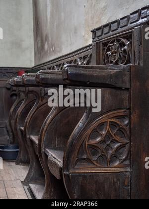 Aus dem 14. Jahrhundert geschnitzte Holzbuden oder Bänke, Kirche St. John the Baptist, Tideswell, Derbyshire, Großbritannien Stockfoto