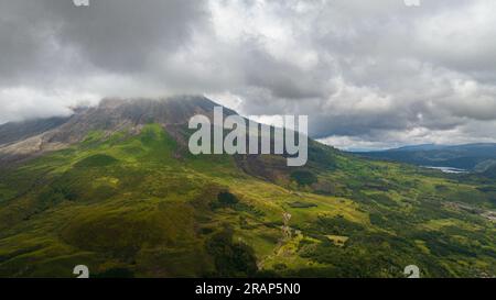 Luftdrohne des aktiven Stratovulkans Sinabung bedeckt mit Wolken. Sumatra, Indonesien. Stockfoto