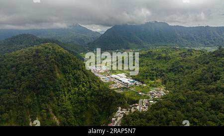 Luftdrohne einer kleinen Stadt inmitten der Berge mit Dschungel und Regenwald. Berastagi, Sumatra. Indonesien. Stockfoto