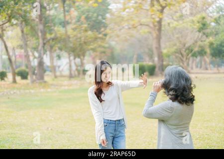 Mutter und Tochter eines asiatischen Teenagers gehen mit Kamera in den Park, um Erinnerungen festzuhalten Stockfoto