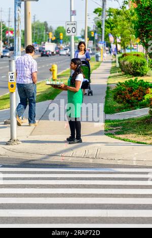 Eine junge Frau serviert Starbucks-Kaffee auf einem Bürgersteig. Stockfoto