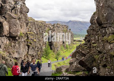 Thingvellir Rift Valley, Island - 06.26.2023: Touristen, die auf dem Kontinentalspalt zwischen der nordamerikanischen und eurasischen tektonischen Platte in Island spazieren Stockfoto