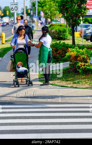 Eine junge Frau serviert Starbucks-Kaffee auf einem Bürgersteig. Stockfoto