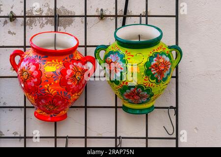 Guadalest, Alicante, Spanien - 14. Januar 2023: Zwei Porzellanvasen mit Griffen. Die Behälter sind mit Blumenmotiven gestaltet. Stockfoto