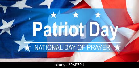 Die Worte Patriot Day 09.11.01 wurden mit silbernen Metallbuchstaben auf Holzbrettfläche mit zerknitterter us-Flagge unten mit Nahaufnahme diagonaler Perspektive gelegt Stockfoto