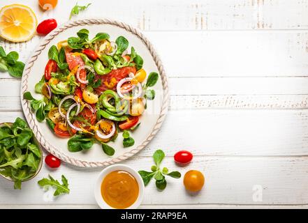 Geräucherter Lachs, Avocado und Kirschtomaten-Salat mit Honig-Senf-Dressing. Gesunder Salat auf einem Holztisch. Draufsicht Stockfoto