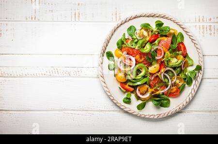 Geräucherter Lachs, Avocado und Kirschtomaten-Salat mit Honig-Senf-Dressing. Gesunder Salat auf einem Holztisch. Draufsicht Stockfoto