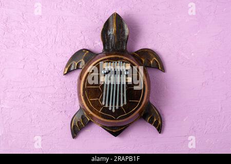 Kalimba Schildkröte. Traditionelle Kalimba aus Holzbrett mit Metall, spielen Sie auf den Händen. Stockfoto