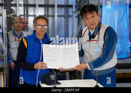 Futaba, Japan. 5. Juli 2023. Rafael Mariano Grossi, Generaldirektor der Internationalen Atomenergie-Organisation, Left, und Tokyo Electric Power Co (TEPCO) Präsident Tomoaki Kobayakawa posieren für ein Foto mit dem Papier, das sie gerade unterschrieben haben, über Vereinbarungen zur Zusammenarbeit mit TEPCO über den Informationsaustausch zur Erziehung der Meereslebewesen, während sie ein Labor im beschädigten Fukushima-Kernkraftwerk in Okuma, Nordosten Japans, am Mittwoch, den 5. Juli 2023 besuchten. (Credit Image: © POOL via ZUMA Press Wire) NUR REDAKTIONELLE VERWENDUNG! Nicht für den kommerziellen GEBRAUCH! Stockfoto