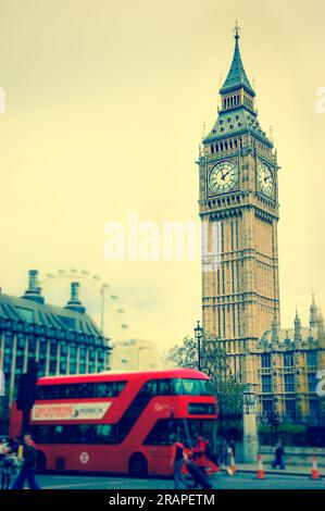 Big Ben und verschwommener roter Doppeldeckerbus, Touristen und London Eye. (London, Großbritannien). Veraltetes Foto. Stockfoto