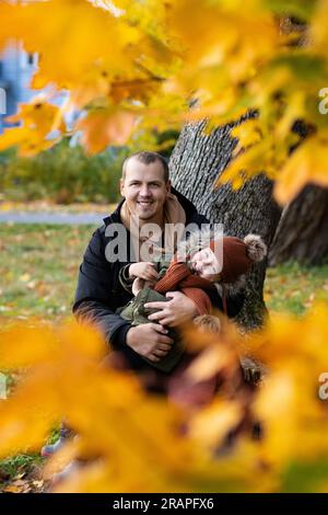 Vater und seine kleine Tochter im Herbstpark haben Spaß Stockfoto