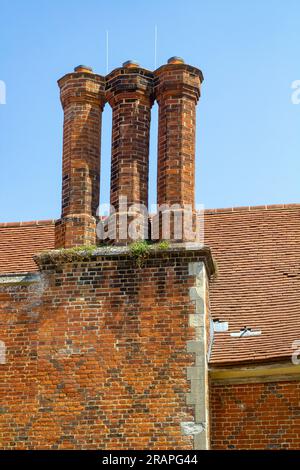 Restaurierte Schornsteine auf dem Dach eines 500 Jahre alten Tudor-Herrenhauses in der Nähe von Basingstoke in Hampshire England. Stockfoto