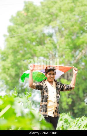 Indischer Junge mit Nationalflagge auf der Farm, glücklicher Junge, Nationalflagge, arme Kinder Stockfoto
