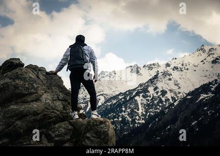 Glücklicher Wanderer, der das Lebensziel erreicht, Erfolg, Freiheit und Glück, Erfolg in den Bergen. Himalaya. Ein Mann steht am Rand einer Klippe Stockfoto