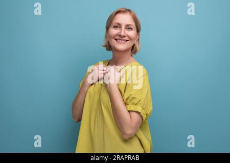 Attraktive blonde Erwachsene Frau mit gelbem Tanktop Pose Stockfoto