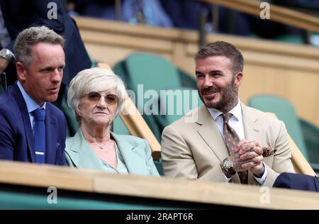 David Beckham begrüßt Luke Donald (links), während er neben seiner Mutter Sandra Beckham in der königlichen Box des Center Court am dritten Tag der Wimbledon Championships 2023 im All England Lawn Tennis and Croquet Club in Wimbledon Platz nimmt. Bilddatum: Mittwoch, 5. Juli 2023. Stockfoto