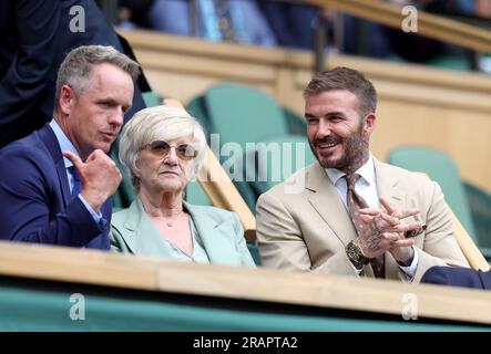 David Beckham begrüßt Luke Donald (links), während er neben seiner Mutter Sandra Beckham in der königlichen Box des Center Court am dritten Tag der Wimbledon Championships 2023 im All England Lawn Tennis and Croquet Club in Wimbledon Platz nimmt. Bilddatum: Mittwoch, 5. Juli 2023. Stockfoto