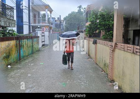 Bei starkem Regen machen sich die Leute auf den Weg. Die unaufhörlichen Regenfälle der letzten Tage haben in Sylhet zu Problemen mit der Wassergewinnung geführt, wobei viele Straßen unter Wasser waren. Aufgrund ungeplanter Baumaßnahmen und eines schlechten Abflusssystems werden diese wasserdurchlässigen Bereiche bei starken Regenfällen und sogar leichten Regenfällen überflutet, so die Einheimischen. Sylhet, Bangladesch. Stockfoto