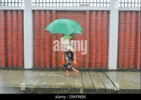 Bei starkem Regen machen sich die Leute auf den Weg. Die unaufhörlichen Regenfälle der letzten Tage haben in Sylhet zu Problemen mit der Wassergewinnung geführt, wobei viele Straßen unter Wasser waren. Aufgrund ungeplanter Baumaßnahmen und eines schlechten Abflusssystems werden diese wasserdurchlässigen Bereiche bei starken Regenfällen und sogar leichten Regenfällen überflutet, so die Einheimischen. Sylhet, Bangladesch. Stockfoto