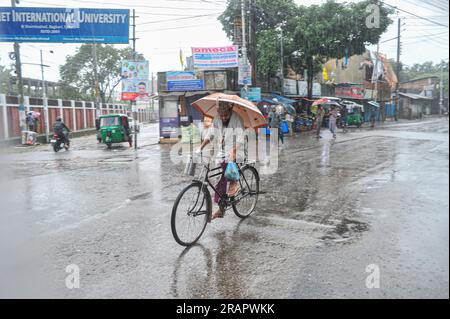 Bei starkem Regen machen sich die Leute auf den Weg. Die unaufhörlichen Regenfälle der letzten Tage haben in Sylhet zu Problemen mit der Wassergewinnung geführt, wobei viele Straßen unter Wasser waren. Aufgrund ungeplanter Baumaßnahmen und eines schlechten Abflusssystems werden diese wasserdurchlässigen Bereiche bei starken Regenfällen und sogar leichten Regenfällen überflutet, so die Einheimischen. Sylhet, Bangladesch. Stockfoto