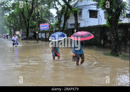 Bei starkem Regen machen sich die Leute auf den Weg. Die unaufhörlichen Regenfälle der letzten Tage haben in Sylhet zu Problemen mit der Wassergewinnung geführt, wobei viele Straßen unter Wasser waren. Aufgrund ungeplanter Baumaßnahmen und eines schlechten Abflusssystems werden diese wasserdurchlässigen Bereiche bei starken Regenfällen und sogar leichten Regenfällen überflutet, so die Einheimischen. Sylhet, Bangladesch. Stockfoto
