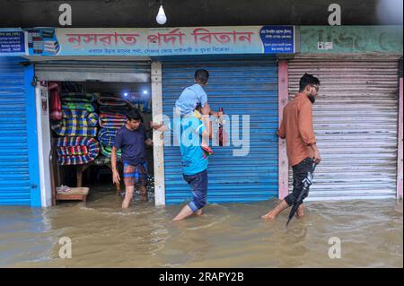 Bei starkem Regen machen sich die Leute auf den Weg. Die unaufhörlichen Regenfälle der letzten Tage haben in Sylhet zu Problemen mit der Wassergewinnung geführt, wobei viele Straßen unter Wasser waren. Aufgrund ungeplanter Baumaßnahmen und eines schlechten Abflusssystems werden diese wasserdurchlässigen Bereiche bei starken Regenfällen und sogar leichten Regenfällen überflutet, so die Einheimischen. Sylhet, Bangladesch. Stockfoto