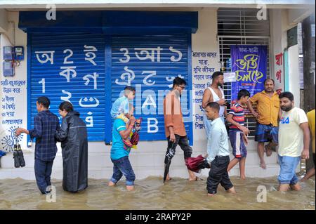 Bei starkem Regen machen sich die Leute auf den Weg. Die unaufhörlichen Regenfälle der letzten Tage haben in Sylhet zu Problemen mit der Wassergewinnung geführt, wobei viele Straßen unter Wasser waren. Aufgrund ungeplanter Baumaßnahmen und eines schlechten Abflusssystems werden diese wasserdurchlässigen Bereiche bei starken Regenfällen und sogar leichten Regenfällen überflutet, so die Einheimischen. Sylhet, Bangladesch. Stockfoto