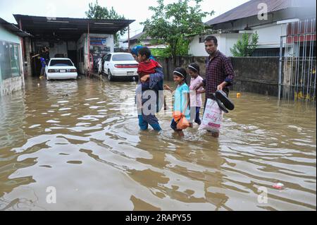Bei starkem Regen machen sich die Leute auf den Weg. Die unaufhörlichen Regenfälle der letzten Tage haben in Sylhet zu Problemen mit der Wassergewinnung geführt, wobei viele Straßen unter Wasser waren. Aufgrund ungeplanter Baumaßnahmen und eines schlechten Abflusssystems werden diese wasserdurchlässigen Bereiche bei starken Regenfällen und sogar leichten Regenfällen überflutet, so die Einheimischen. Sylhet, Bangladesch. Stockfoto