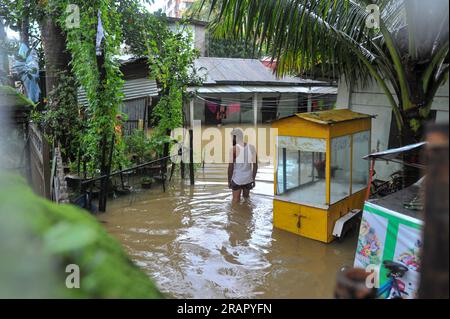 Bei starkem Regen machen sich die Leute auf den Weg. Die unaufhörlichen Regenfälle der letzten Tage haben in Sylhet zu Problemen mit der Wassergewinnung geführt, wobei viele Straßen unter Wasser waren. Aufgrund ungeplanter Baumaßnahmen und eines schlechten Abflusssystems werden diese wasserdurchlässigen Bereiche bei starken Regenfällen und sogar leichten Regenfällen überflutet, so die Einheimischen. Sylhet, Bangladesch. Stockfoto