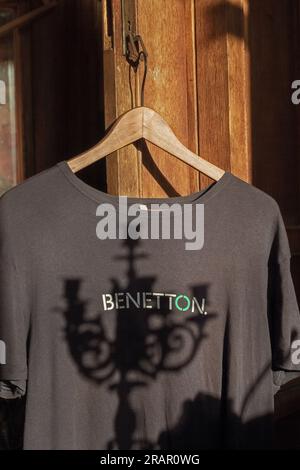 Dunkles benetton-T-Shirt auf Holzbügeln für die Stimmung der Crew Stockfoto