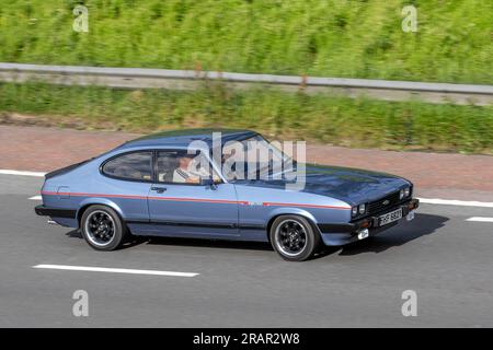 1983 80s Eighties Blue British Ford Capri Injection, V6 Car Hatchback Benzinmotor 2792 cm3; Fahrt mit hoher Geschwindigkeit auf der Autobahn M6 im Großraum Manchester, Großbritannien Stockfoto